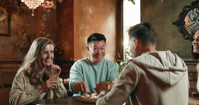 Diverse friends, sitting in restaurant and eating pizza during spare time