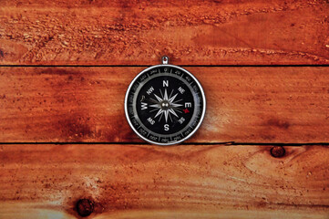 Navigation compass on wooden table background