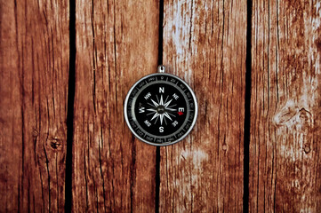 Navigation compass on wooden table background