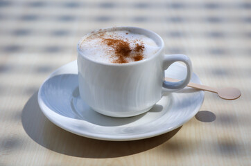 Ein Tasse mit Latte macchiato, Cafe Latte steht auf einem Tisch.