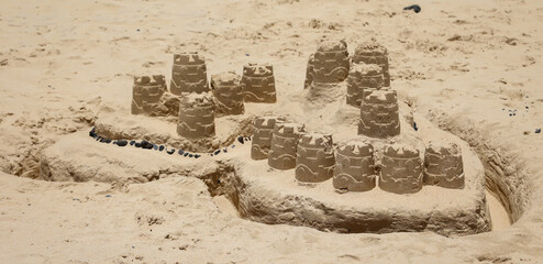 Eine Sandburg, Kleckerburg an einem Strand gebaut mit Kinderspielzeug.