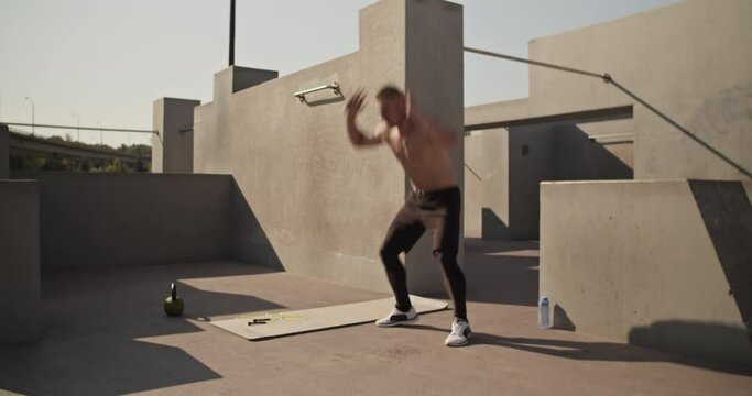Sportsman doing burpee exercise on street