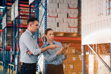 Warehouse manager talking and using digital tablet while checking product in warehouse, Logistic industry concept.