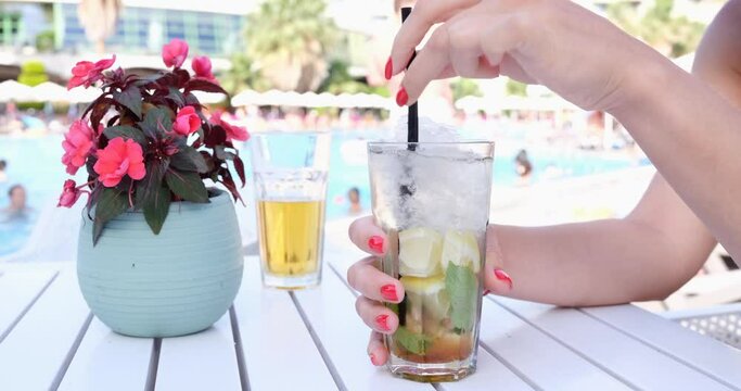 Woman's hands with a summer cocktail on the beach