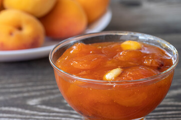 Apricots on the table and apricot jam in a glass bowl.