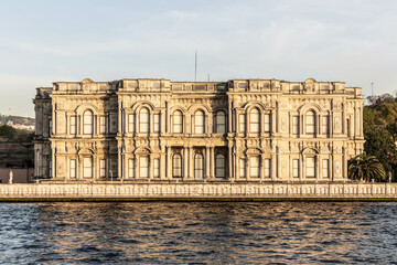 Beylerbeyi Palace on the coastline of Bosporus strait in golden hour. View from touristic boat on...