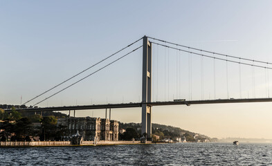 Beylerbeyi Palace under 15 July Martyrs Bridge at sunset. View from touristic boat on Bosporus. Istanbul, Turkey
