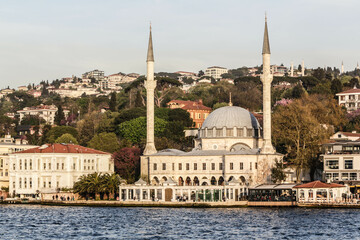 Fototapeta na wymiar Istanbul, Turkey - April 2022: Locals fish in the waters of the Bosphorus outside Beylerbeyi Mosque, also known as Hamid-i Evvel Camii, in Beylerbeyi in the Uskudar district of Istanbul