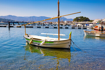 Naklejka na ściany i meble Small fishing boat with sail is anchored in the port of Port of Selva, Costa Brava, Catalonia, Spain