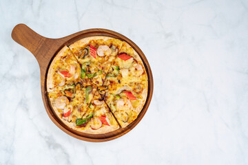 top view of tasty hot baked seafood crispy pizza - mussels, shrimps and kani with chili pepper and...
