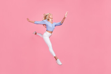 Fototapeta na wymiar Full length photo of pretty sweet girl dressed blue top jumping high running empty space isolated pink color background