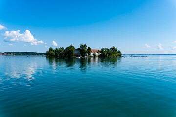 Obraz premium Fraueninsel panorama at summer with a blue sky and sun