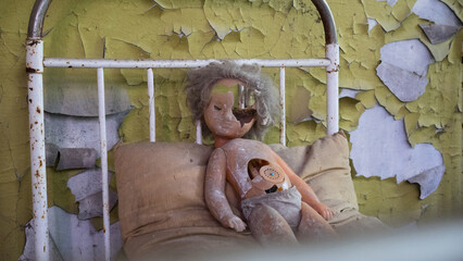 Plastic doll on rusty beds in abandoned kindergarten in city Pripyat near Chernobyl nuclear power plant. Exclusion radioactive zone, ghost town, Ukraine. Radiation, catastrophe