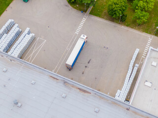 Aerial view of goods warehouse. Logistics center delivery in industrial city zone from above. Aerial view of trucks loading at logistic center