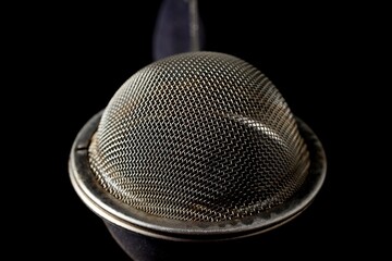 metal strainer for brewing loose tea close-up on a black background
