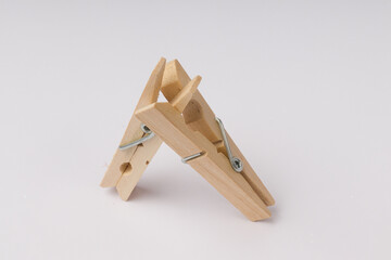 two linked wooden clothespins on a white background