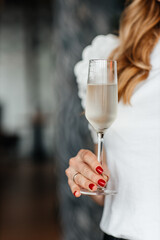 woman holds a glass of cold prosecco in her hand