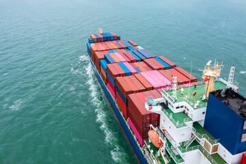 Fototapeta premium aerial back view of container ship carrying cargo container import export internatioonal and worldwide, business and industry goods logistic transportation by container ship in open sea,