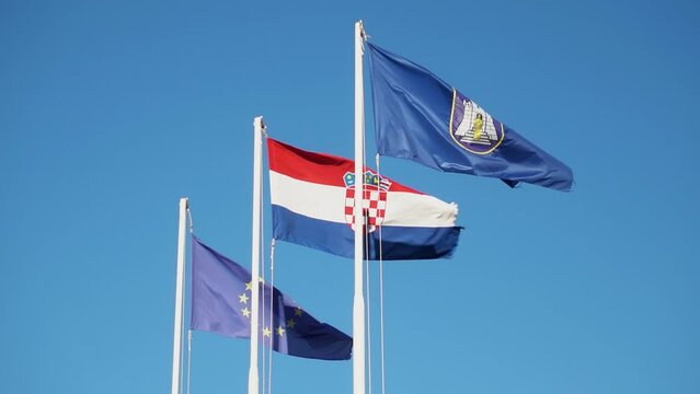 National Flags Of European Union, Croatia, And A Local Flag Waving On The Sky. Slow Motion