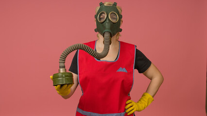 portrait of a woman in a vintage gas mask, apron and gloves on a colored background, studio shot