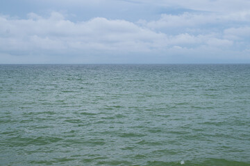 Fototapeta na wymiar Calm and peaceful nothern sea in a cloudy weather. Baltic sea summer background