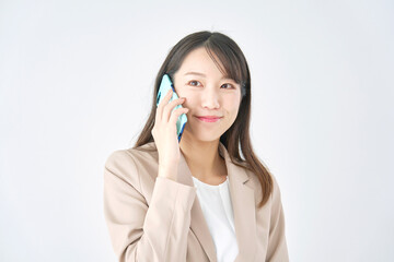 スマホで電話するビジネスウーマン　白バック