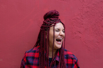 Portrait smiling young woman with red dreadlocks wearing a red checkered shirt