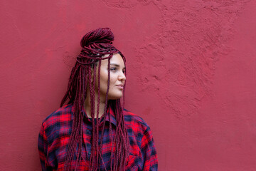 Portrait of young woman with red dreadlocks wearing a red checkered shirt