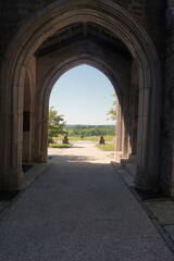 Obraz premium Covered Exterior Stone Walkway Overlooking Sunny Grassy Field