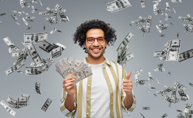 finance, currency and people concept - happy man holding hundreds of dollar money banknotes showing...