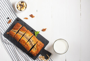 Banana bread or cake on white wooden table. Delicious homemade dessert, tasty snack or morning breakfast.