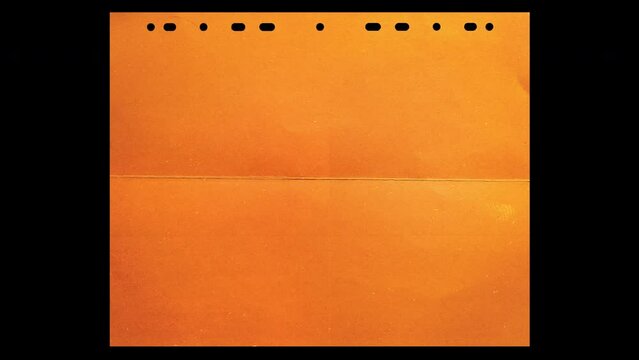 folded orange divider sheet paper isolated on black background. cool video paper 4k overlay with luma mask.