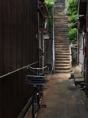 階段に続く路地に置かれた自転車
