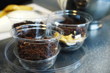 The process of preparing a multi-layered dessert. Confectioner lays out layers of nuts, caramel and biscuit in a plastic mold