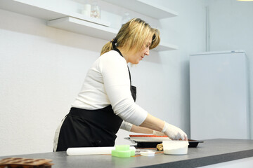 Woman cook put heart shaped dough from baking mat on a baking sheet. Gingerbread baking
