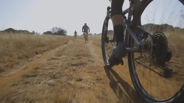 A slow motion shot of mountain bikers who are riding their bikes on the rocky road in day time