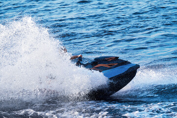 Jet ski close-up at speed, water splashes in different directions. The rider is not visible in the...