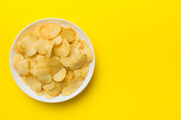 Potato chips on bowl isolated on colored background. Delicious crispy potato chips in bowl. Space for text. Top view