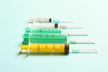 Top view of medical syringes with needles at blue background with copy space. Injection treatment...
