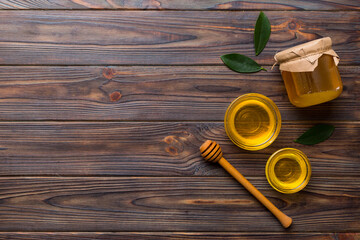 Honey jar with wooden honey dipper on white background top view with copy space. Delicious honey bottle