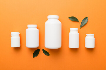 supplement pills with medicine bottle health care and medical top view. Vitamin tablets. Top view mockup bottle for pills and vitamins with green leaves, natural organic bio supplement, copy space