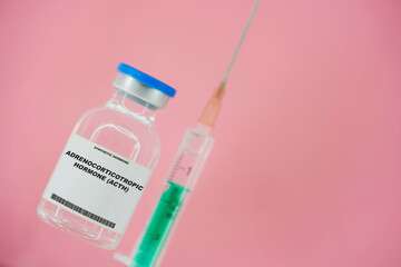Adrenocorticotropic hormone (ACTH). Test tube with artificial hormone on pink background...