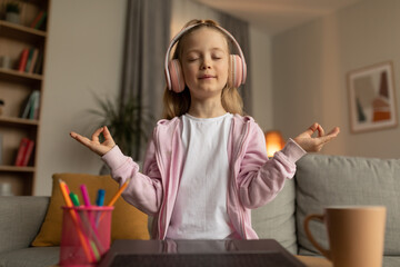Little Girl Meditating Online Sitting Near Laptop At Home