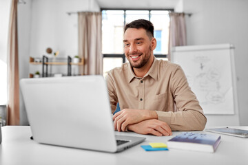 distance education, school and remote job concept - happy smiling male teacher with laptop working...
