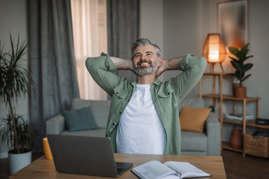 Glad Old European Man With Beard Take Break At Workplace With Laptop, Rest At Free Time In Living Room