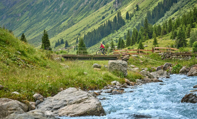 nice active senior woman riding her electric mountain bike in the silvretta mountain range near Gaschurn, Tyrol, Austria