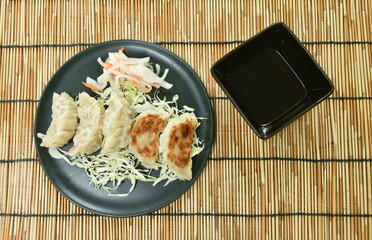 crispy fried Gyoza or Japanese dumpling stuffed mashed pork dipping shoyu sauce on plate