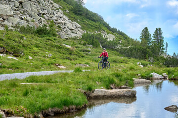 nice active senior woman riding her electric mountain bike in the silvretta mountain range near...