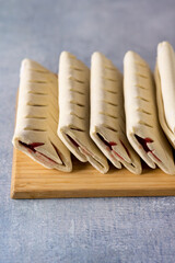 Homemade Uncooked Puff Pastry Buns on Wooden Board Blue Background Vertical Semi-Finished Products