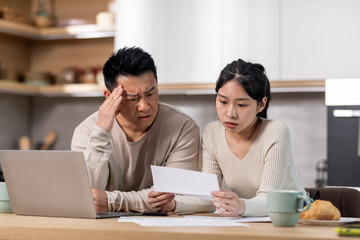Obraz na płótnie Canvas Upset korean husband and wife reading letter, kitchen interior